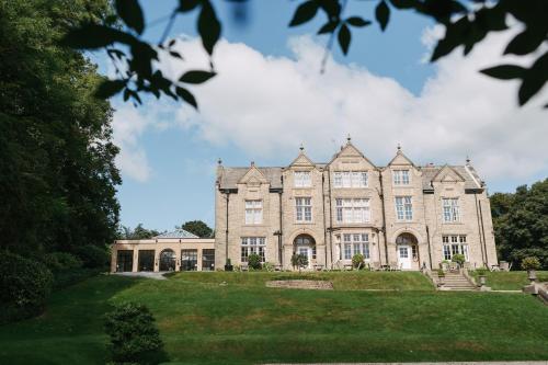 an image of a large stone building with a lawn at Woodlands Hotel in Leeds