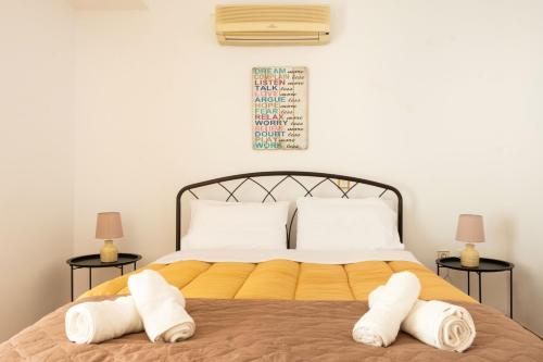 カラマタにあるThe home sweet home - Family friendly 2 floor apartmentの白いタオルが敷かれたベッドのある寝室