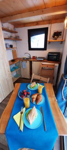 a table with plates of food on a blue table cloth at Tiny House Retreat Bran in Bran