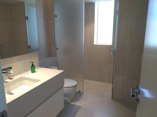 La salle de bains est pourvue d'un lavabo, de toilettes et d'une douche. dans l'établissement Super Luxury 2 BR Apartment in Five Star Colombo City Centre, à Colombo