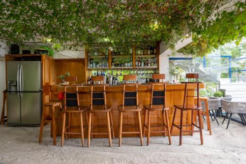 un bar con sillas de madera y nevera en El Dragon Hotel, en San Marcos La Laguna