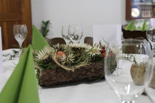 a table with wine glasses and a basket of plants at Hotel Urirotstock in Isenthal