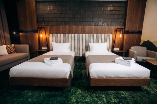 a hotel room with two beds and a couch at MORVA Premium Spa Resort in Yaremche