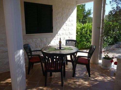 a table and chairs on a patio with a window at Apartments Suzana in Ždrelac