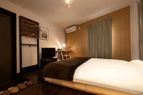 a bedroom with a large white bed and a television at Apartment Sun Bright - Vacation STAY 89260v in Tokyo