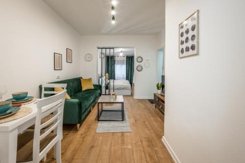 a living room with a green couch and a table at Atomium apartments in Tirana