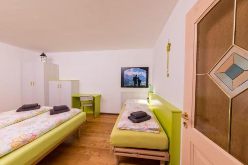 a room with two beds and a table at Casa Trettel in Tesero