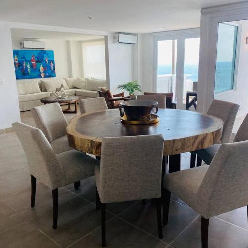 a living room with a wooden table and chairs at Bello Departamento Veleros frente al mar in Acapulco