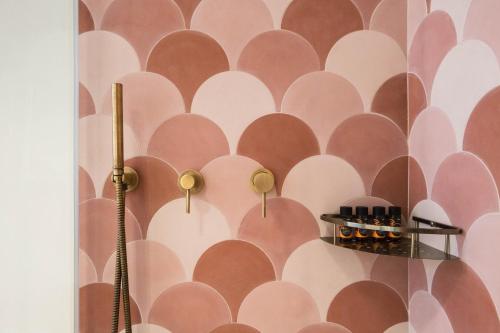 a bathroom with a pink and white wallpaper at Neratze Hammam Suites in Rethymno Town