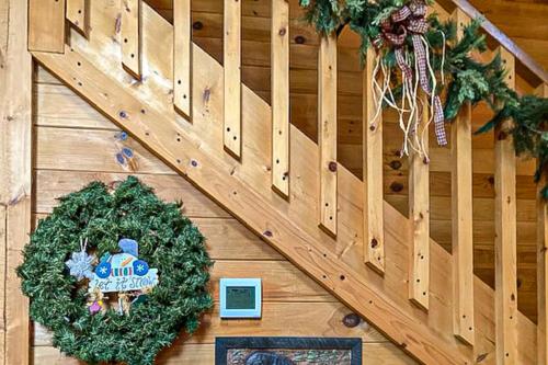 a christmas wreath on a wooden wall with a staircase at Pine Cone Ridge in Sevierville
