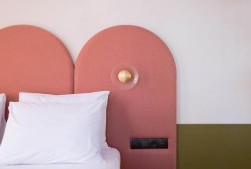 a bedroom with a bed and a wall with a light at Neratze Hammam Suites in Rethymno Town