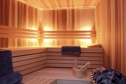 a sauna with a bench and a bucket in it at Parkhotel Kortrijk in Kortrijk