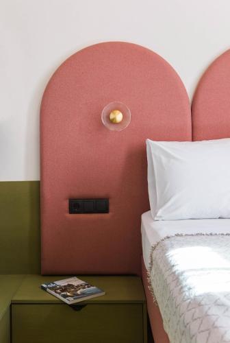 a bedroom with a red headboard with a white bed at Neratze Hammam Suites in Rethymno Town