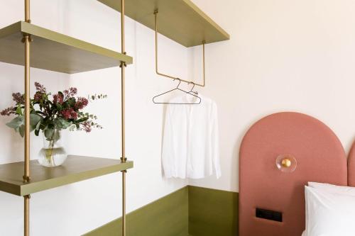 a bedroom with a shelf and a vase of flowers at Neratze Hammam Suites in Rethymno Town