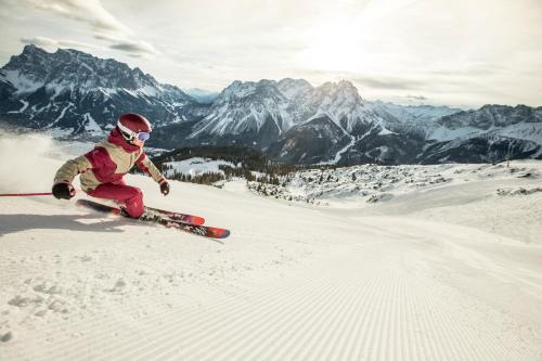 a person is skiing down a snow covered mountain at Alpenflair in Berwang