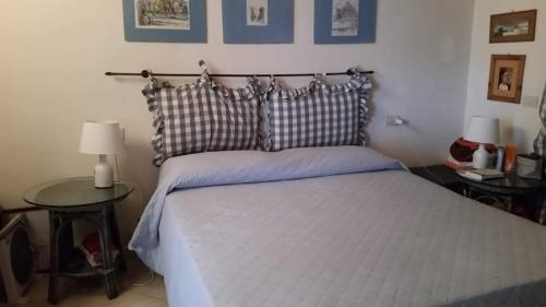 Un dormitorio con una cama grande con dos mesas. en La casa di Camilla a Punta Molara, en Monte Petrosu