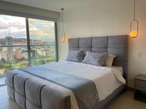 NUEVA Suite-Piso 21 Vista La Carolina @ONE Quito tesisinde bir odada yatak veya yataklar