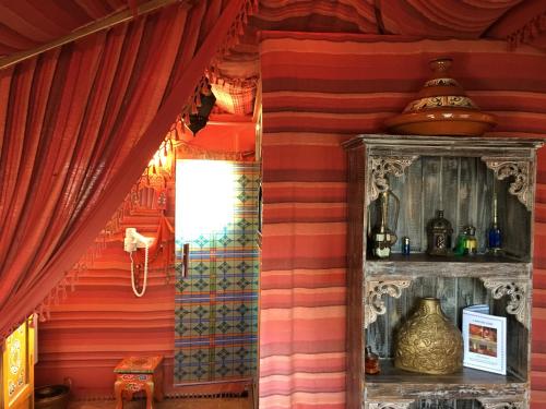 a room with red walls and red curtains at Domaine De La Carrauterie by Terre Insolite in Sautin