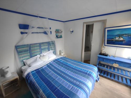 a bedroom with a blue and white bed and a dresser at Domaine De La Carrauterie by Terre Insolite in Sautin
