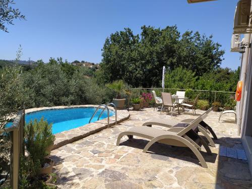 un patio avec un banc et une piscine dans l'établissement "Villa Kastania" Melidoni, Crete, à Melidhónion