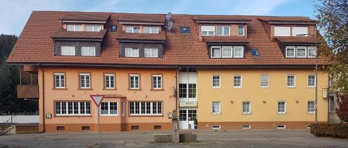 un grand bâtiment avec un toit brun dans l'établissement Andi´s Steakhüsli & Hotel, à Schopfheim