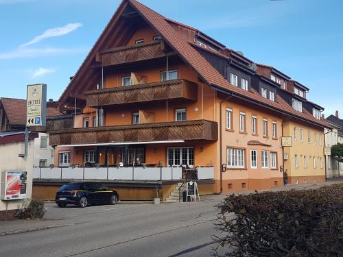 un bâtiment avec une voiture garée devant lui dans l'établissement Andi´s Steakhüsli & Hotel, à Schopfheim
