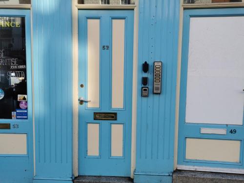 a blue door on a building with two windows at The Captains Quarters in Scarborough