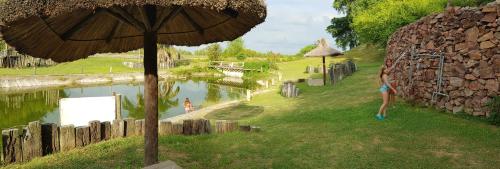 Una mujer parada junto a un lago con un paraguas. en amanecer de RIO y pesca, en San Pedro