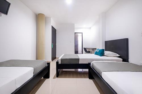 Habitación con 2 camas y una silla. en Ayenda RM, en Barrancabermeja