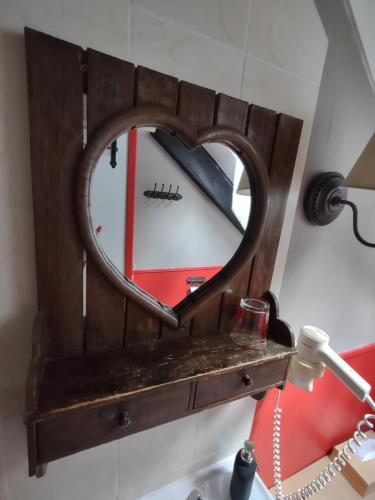 a mirror in the shape of a heart on a wall at Domaine De La Carrauterie by Terre Insolite in Sautin