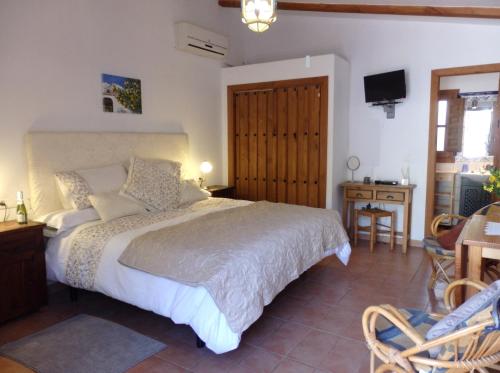 a bedroom with a bed and a table and a chair at Escuela La Crujía in Vélez-Málaga