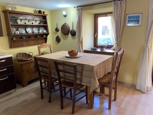 a kitchen with a table with chairs and a window at Jack's Nest in Campertogno