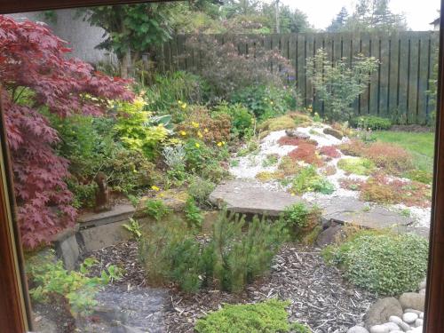 a garden with flowers and a wooden fence at Middleton House Bed and Breakfast in Auchterarder