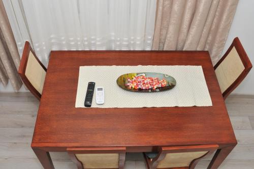 a table with a bowl of sprinkles and a remote control at "Astor16" Apartments in Niš