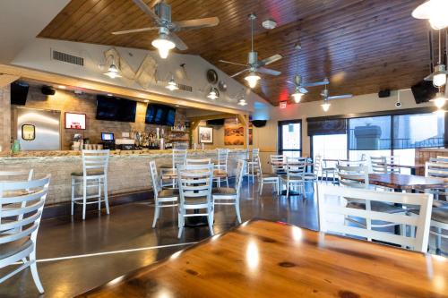 a dining room with white chairs and a bar at Holiday Inn Club Vacations at Desert Club Resort in Las Vegas