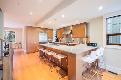 a kitchen with a large island with bar stools at Fitzsimmons Walk by Outpost Whistler in Whistler