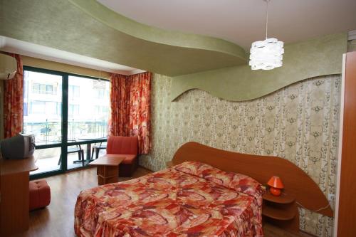 a bedroom with a bed and a large window at Tanya Hotel in Sunny Beach