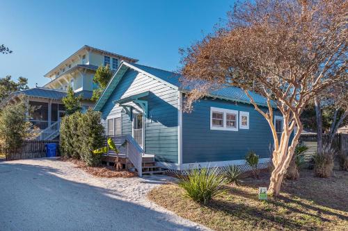 ein blaues Haus mit einem Baum davor in der Unterkunft W Cooper 317 in Folly Beach