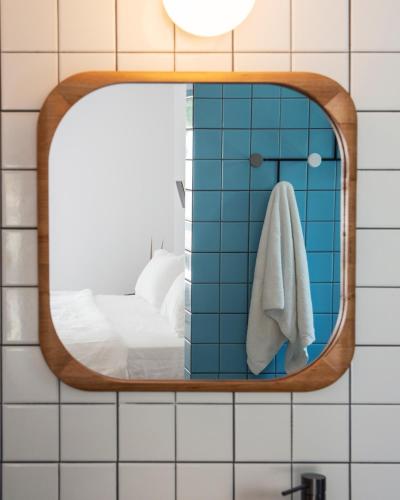 La salle de bains est pourvue d'un miroir sur un mur carrelé. dans l'établissement l'Atelier des Milles Roches, à Gordes