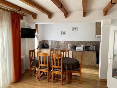 a kitchen and dining room with a table and chairs at Apartaments Casa Vella Popaire in Soldeu