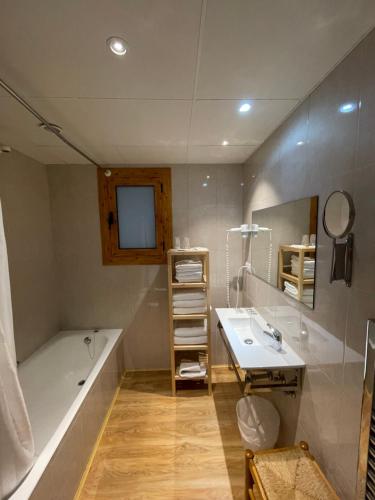 La salle de bains est pourvue d'une baignoire, d'un lavabo et d'une baignoire. dans l'établissement Apartaments Casa Vella Popaire, à Soldeu