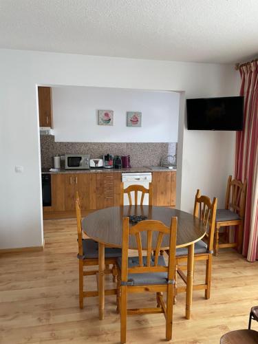 a kitchen and dining room with a table and chairs at Apartaments Casa Vella Popaire in Soldeu