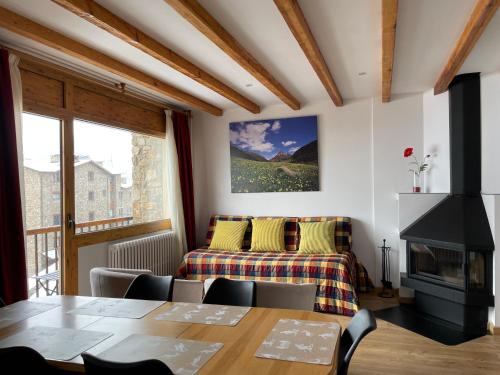 a living room with a table and a bed at Apartaments Casa Vella Popaire in Soldeu
