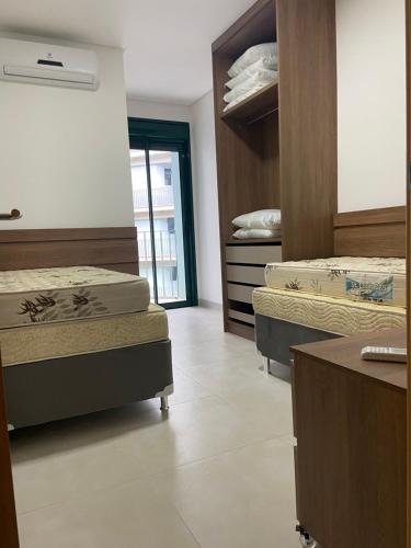 a room with two beds in a room at DNA UBATUBA in Ubatuba