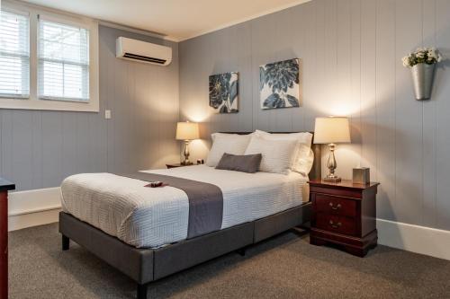 a bedroom with a bed and two lamps and a window at Homestead Inn in New Milford