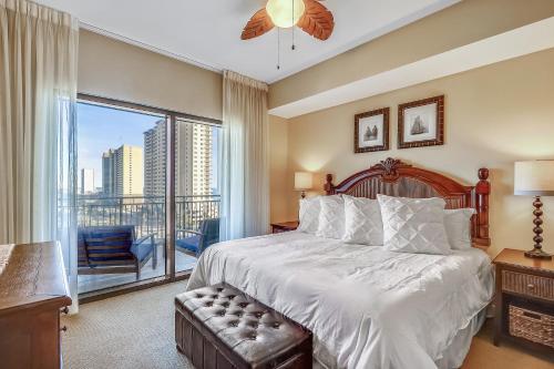 a bedroom with a large bed and a large window at Origin at Seahaven #831 by Book That Condo in Panama City Beach