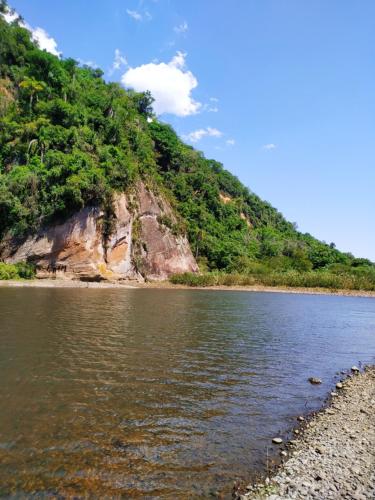 a view of a river next to a mountain at hotel fazenda vale real in Nova Petrópolis