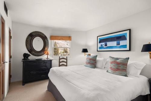 a bedroom with a white bed and a mirror at Shadow Mountain 10 in Aspen