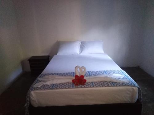 a bedroom with a bed with a flower on it at Hostal Y Balneario La Danta in El Zaino