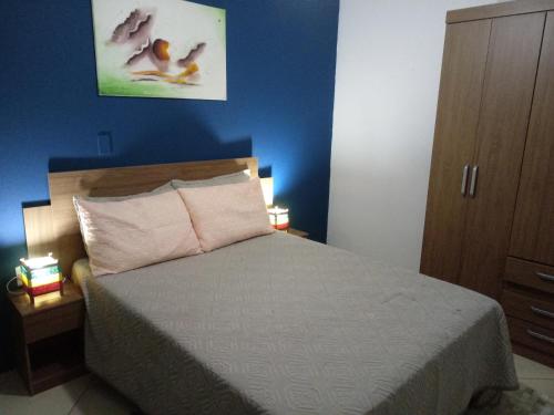 1 dormitorio con cama y pared azul en Casa com vista para o mar en Capão da Canoa